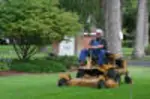 Kane operating a commercial zero-turn mower for Monroe Lawn Care